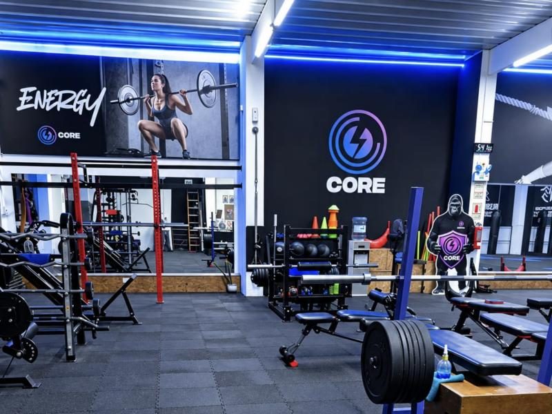 Zona de pesas de Core Gym con el logo en la pared